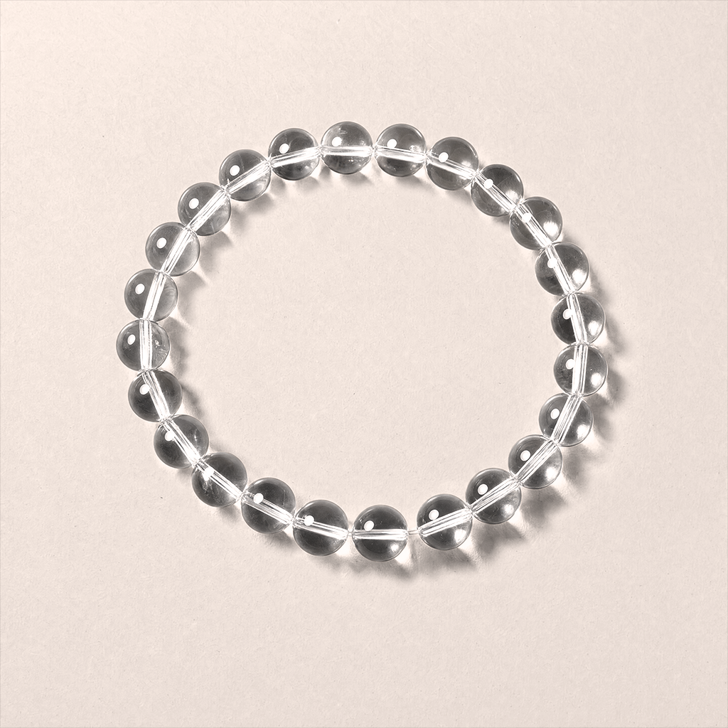 Aura Reset clear quartz round-bead bracelet on a neutral background